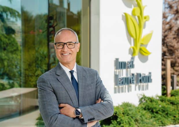 Navid Sariolghalam, General Manager of Inn at Laurel Point standing outside of hotel lobby smiling with arms crossed
